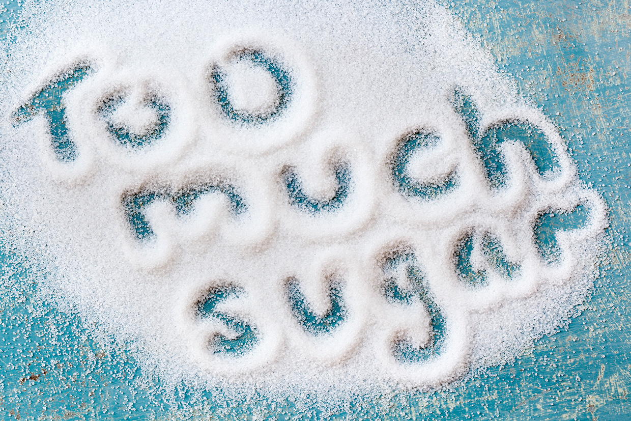 The words "too much sugar" written in sugar grains.  Overhead view.